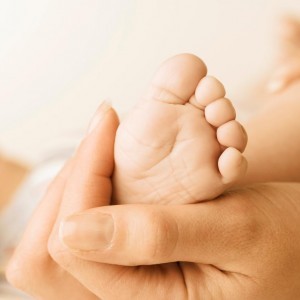 mother holds infant's foot