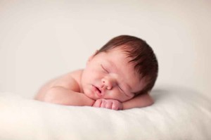 baby resting with head on arms