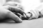 baby reaching for father's finger